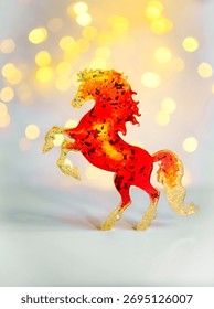 Un cheval miniature rouge vif sur fond clair avec effet bokeh. Symbole 2026