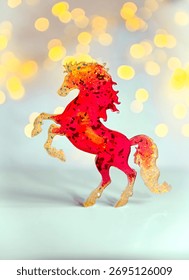 Un cheval miniature rouge vif sur fond clair avec effet bokeh. Symbole 2026
