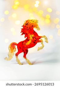 Un cheval miniature rouge vif sur fond clair avec effet bokeh. Symbole 2026
