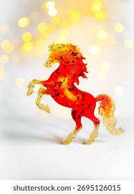 Un cheval miniature rouge vif sur fond clair avec effet bokeh. Symbole 2026