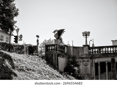 Ljubljana, Slovenia – 14 Juli 2025: Foto close-up salah satu patung naga ikonis di Jembatan Naga (Zmajski most), simbol kota. Jembatan bergaya Art Nouveau ini selesai dibangun pada tahun 1901.