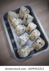 寿司海苔で巻く前のおにぎりのクローズアップ。ツナマヨ、チキン照り焼き、ビーフ照り焼きなど、様々な具材が揃っています。