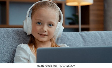 Kafkasyalı mutlu çocuk, kulaklıklı, dizüstü bilgisayarlı, kameraya bakan, evde gülümseyen, çocuk portresi, bilgisayar oynayan, ekrana bakan, müzik dinleyen, çizgi film izleyen, okul, çevrimiçi kurs