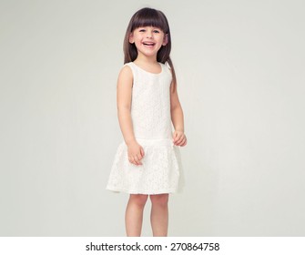 長い髪とカメラに笑顔の白いドレスでかわいい女の子