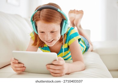 Kulaklık, tablet ve evdeki kanepede kızla kitap okuma, yayın hizmeti, çizgi film uygulaması veya arama. Çevrimiçi film aboneliği, multimedya ve müzik için dairenin oturma odasında çocukla oyunlar.