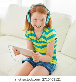 Kulaklık, tablet ve evde kanepede oturan kız portresi, yayın hizmeti, çizgi film uygulaması ve arama için. Çevrimiçi film aboneliği, multimedya ve müzik için evin oturma odasındaki çocukla gülümseme.