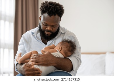 Čierny otec drží spiace novonarodené dieťa. Roztomilé batoľa s otcom, rodinnou láskou a ochranou svojho syna v spálni doma.