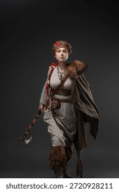 Heroinë skandinave fantastike me sëpatë beteje, e veshur me pelerinë leshi në gri neutrale.