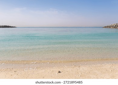 Mirna morska voda sreča peščeno obalo na plaži v mirnem dnevu