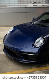 屋上駐車場で雨の中撮影された本物の高級スポーツカー 濡れたボディワークとドラマチックな照明が特徴の高性能スーパーカー 都市の夜景における本物のスポーツカーの後方からの眺め