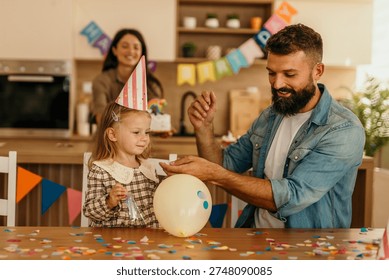 Vater und Tochter feiern Geburtstag mit Konfetti und Luftballons