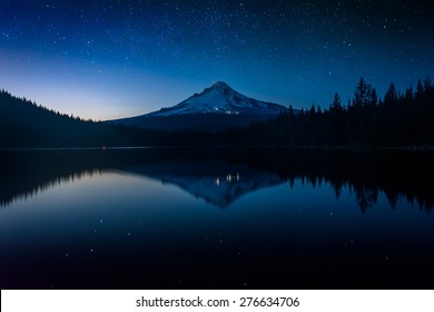 Sterne am Nachthimmel und Mount Hood spiegeln sich nachts im Trillium Lake im Mount Hood National Forest, Oregon.