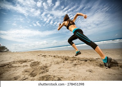 Biegająca kobieta, biegaczka uprawiająca jogging podczas treningu na świeżym powietrzu na plaży, modelka fitness na świeżym powietrzu.