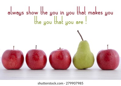白い木のテーブルの上に、小さな赤いリンゴの列に大きな緑の梨が1つ付いた、常にあなたの中のあなたを見せるというコンセプトの果物の列。