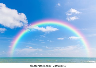 青い空と雲と海にかかる虹。