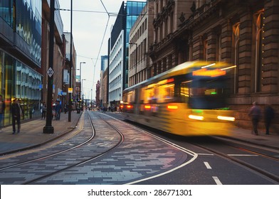 Light rail Metrolink tram in the city center of Manchester, UK in the evening. The system has 77 stops along 78.1 km and runs through seven of the ten boroughs