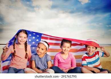 穏やかなビーチの風景に対してアメリカ国旗を持つ子供たち
