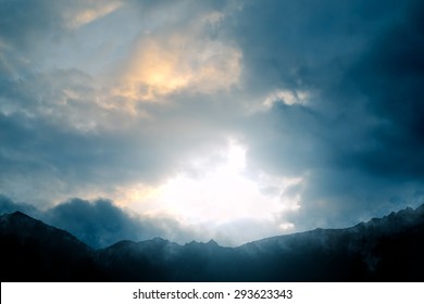 Montañas y cielo - Paisaje de montaña con nubes dramáticas, sol y neblina - imagen generada por computadora