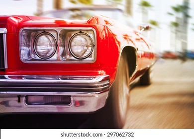 Coche deportivo clásico rojo conduciendo rápido, con efecto de desenfoque de movimiento. Cerrar vista.