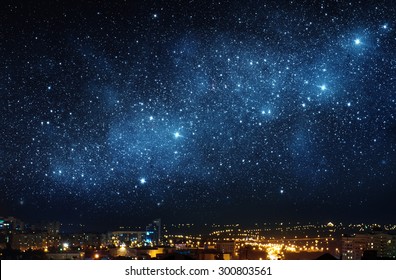 City landscape at nigh with sky filled with stars. Elements of this image furnished by NASA.