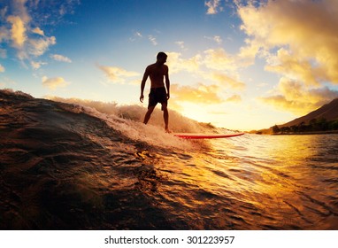 サンセット サーフィン。日没で波に乗る若い男。アウトドア アクティブ ライフ スタイル。