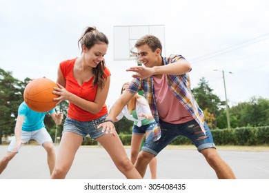 sommerferien, sport, spiele und freundschaftskonzept - gruppe glücklicher teenager, die draußen basketball spielen