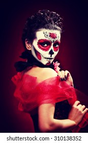 halloween maquillaje calavera de azúcar hermosa modelo con peinado perfecto. Concepto de santa muerte. Tonificación retro de moda.