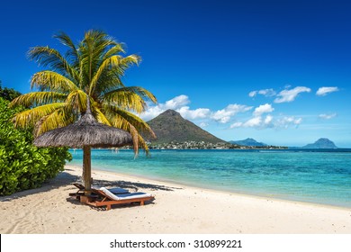 Tumbonas y sombrillas en la playa tropical en Isla Mauricio, Océano Índico