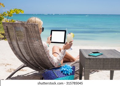 Žena koristi digitalni tablet na plaži