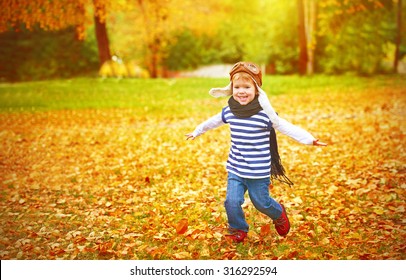 happy child playing pilot aviator and dreams outdoors in autumn