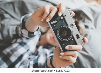 Soft photo of woman in checkered shirt taking a photo, top view point