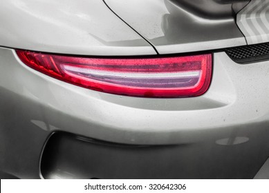 Tail light of sport grey car with rain drops and shadows. Closeup headlights of car. Modern luxury car close-up banner background. Concept of expensive, sports auto Closeup headlights Porsche 911