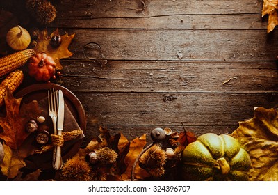 Makan malam syukur. Buah musim gugur dengan piring dan peralatan makan. Latar belakang Thanksgiving musim gugur