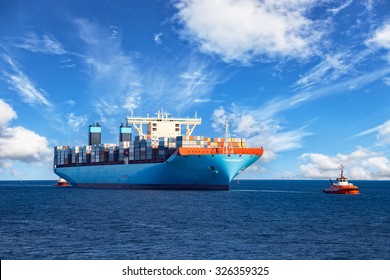 Schlepper, die Containerfrachtschiffen beim Hafen helfen.