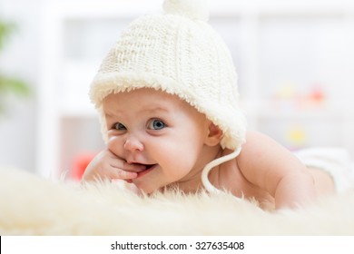 Nettes kleines Mädchen, das die Kamera untersucht und in weißem Hut getragen wird.