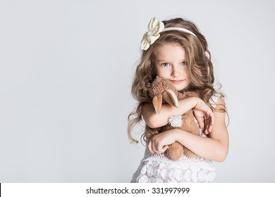 Smuk lille pige, der krammer sin legetøjskanin