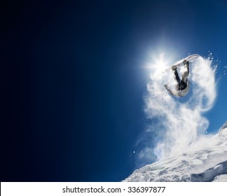 Snowboarder membuat lompatan tinggi di langit biru cerah