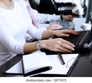 Primer plano de manos humanas. Los jóvenes oficinistas están escribiendo en teclados frente a las computadoras de su oficina.