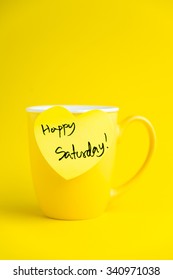 Happy Saturday message on yellow mug.