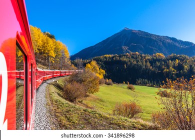 Travel with train of Rhaetian Railway in golden autumn through the line of Glacier Express in Engadin, Canton of Grisons, Switzerland.