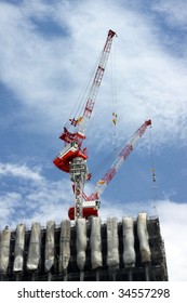 Two building cranes on a skyscraper construction site in Tokyo, Japan
