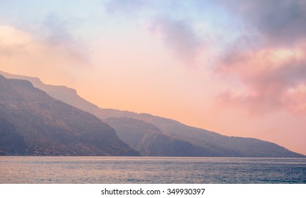 Paisaje montañoso al amanecer - cielo nublado en colores pastel para tu diseño, serenidad y cuarzo rosa. Paisaje marino romántico - vista al mar con siluetas de colinas azules en la niebla.