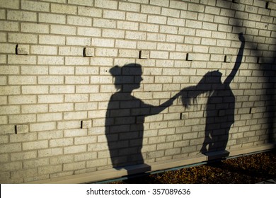 女性は戦い、髪を引っ張ります。壁に映る影。