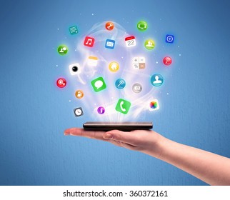 デバイスの図の概念の上にデジタル アプリケーションのロゴが表示されたプロファイル ビューから携帯電話タブレットを持っている白人男性の手