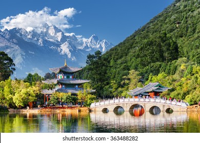 中国雲南省麗江の玉龍雪山と黒龍池の素晴らしい景色。池に架かる蘇翠橋と玉泉公園の月抱亭。