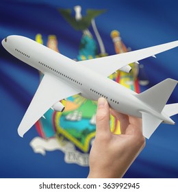 Airplane in hand with local US state flag on background series - New York