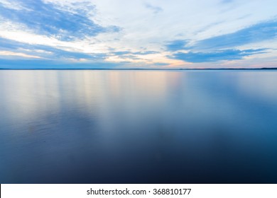 穏やかな平らな面で長時間露光で撮影した平和で静かな水の風景