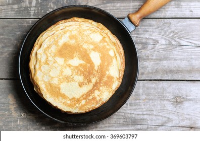 Stack of pancakes on a cast-iron frying pan. Top view. Flat lay
