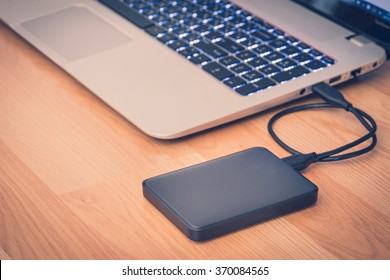 overdracht of back-up van gegevens tussen laptop en externe harde schijf op de desktopstilleven op kantoor