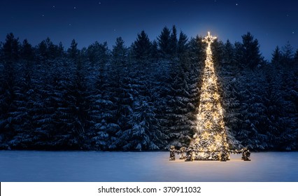 Pohon natal yang menyala di salju di malam hari dengan ruang fotokopi
